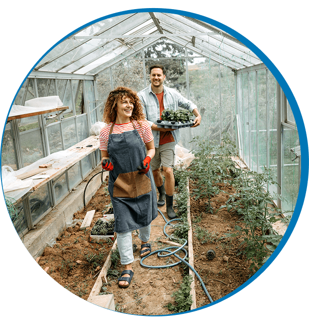 Greenhouse gardening duo with harvested vegetables