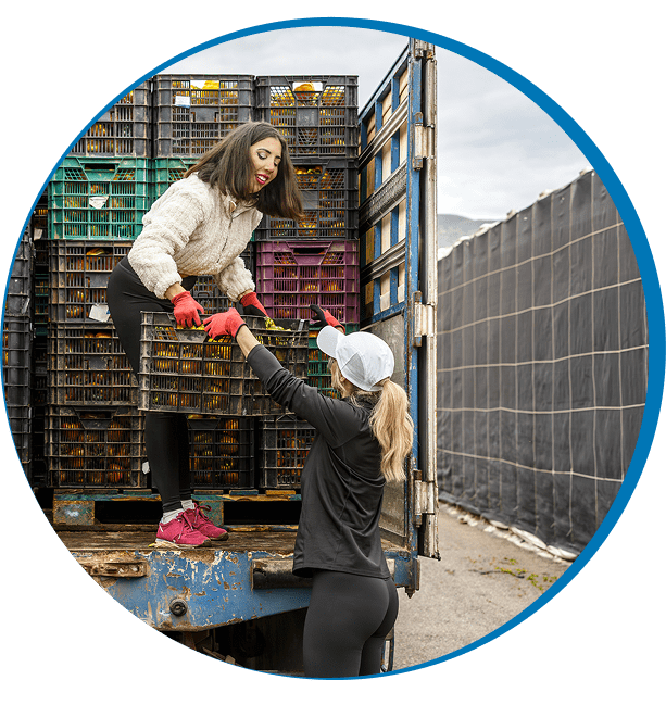 Women unloading crates from truck
